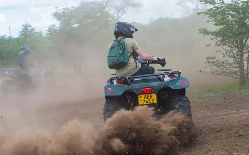 A rider kicking up dust on a quad-bike trail